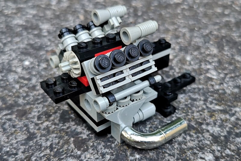 Ausgebauter Motorblock aus LEGO-Steinen. Achtzylinder mit Chrome-Auspuffrohren.