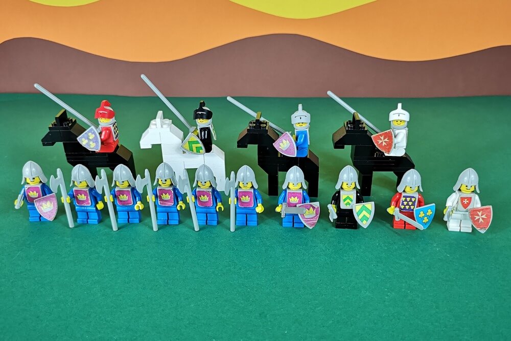 Alle Minifiguren und Pferde der gelben Burg auf einem Bild zusammen. 