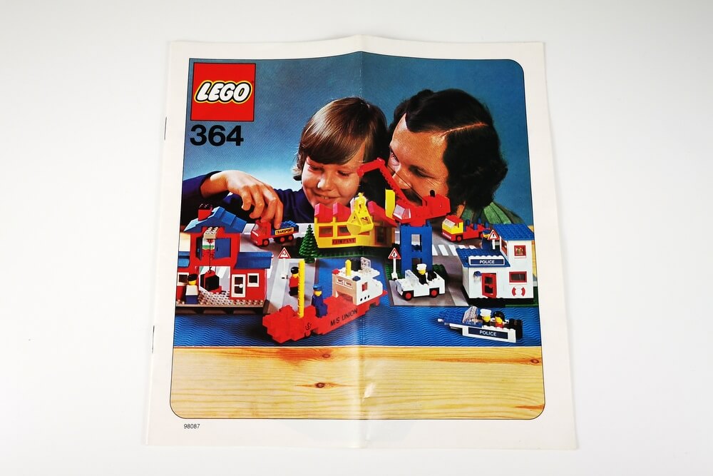 Das Front-Cover der Bauanleitung von LEGO-Set 364. Zu sehen ist ein Vater mit seinem Kind und das große LEGO-Spielset.