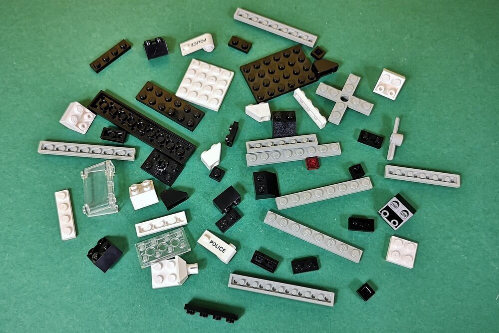 52 schwarze, graue und weiße Teile, aus denen der Helikopter zusammengesteckt wird. So sah Lego früher aus. Konstruktionsspielzeug, wie es sein soll. 