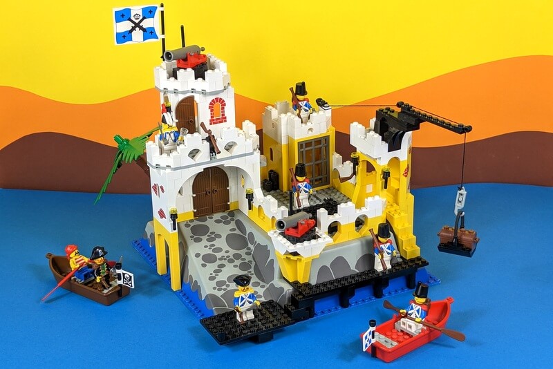 Das fertige Eldorado Fortress auf einem Bild mit allen Minifiguren vor einem schönen bunten Hintergrund aus Pappe.
