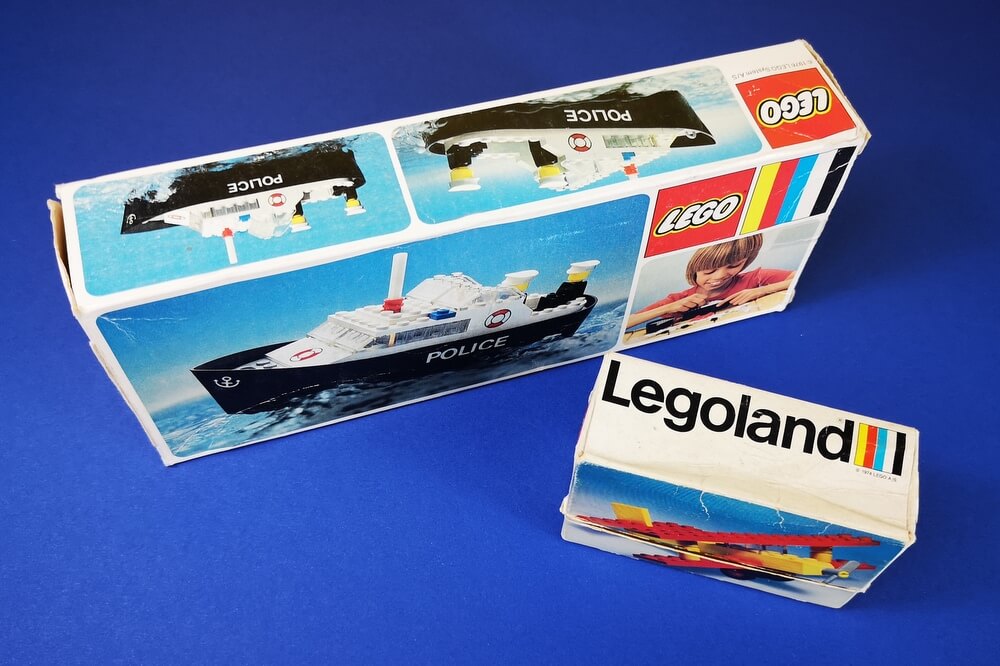 Die Box von Lego-Set 613 (kleines Flugzeug) ist von 1974 und hat auf der Seite der Box einen Legoland-Schriftzug. Das Polizeiboot (lego 314) hat keinen Legoland-Schriftzug auf der Box, obwohl das Set zwei Jahre später herauskam. Auf dem Bild sind beide Boxen im Vergleich gezeigt. 