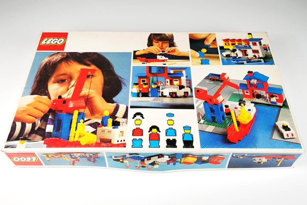 Rückseite des seltenen Kartons von LEGO-Set 364. Zu sehen sind mehrere Bilder, wie Kinder mit dem LEGO-Set spielen. Dabei fallen die tollen bunten und einfachen LEGO-Steine der 70er-Jahre auf.