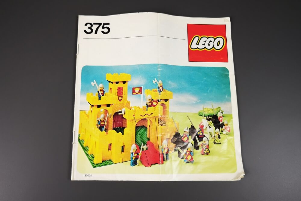 Auf der Bauanleitung sieht man die gelbe Burg. Die Anleitung ist geklammert und sehr schmal. Typisch für alte LEGO-Bauanleitungen ist, dass in wenigen Bauschritten viele Teile verbaut werden. 