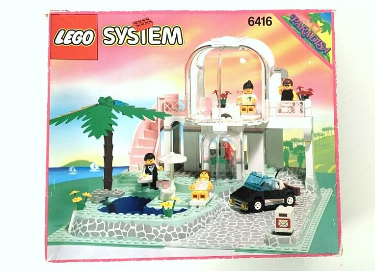 Zu sehen ist die Box des Paradisa-Sets von LEGO mit der Setnummer 6416. Man sieht eine Ferienvilla mit Pool, Haus und Palme. Es dominieren typisch für die Serie Paradisa die Farben rosa und weiß.