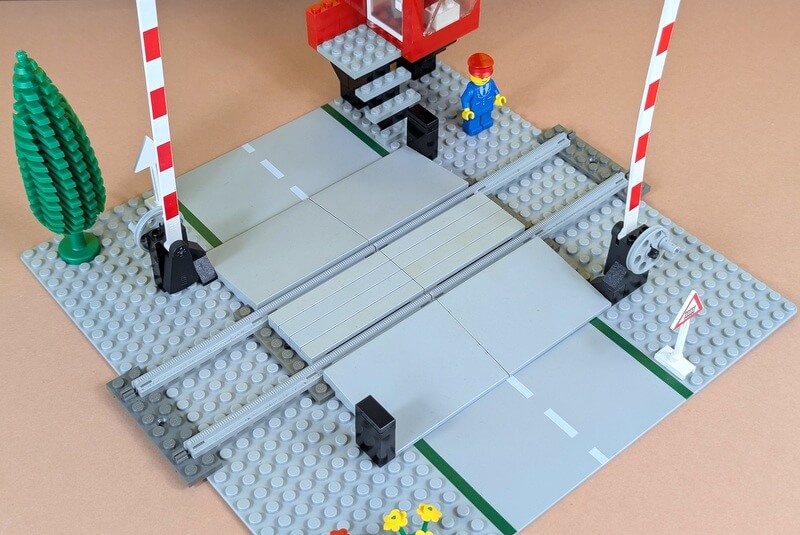 Lego-Bahnübergang von oben fotografiert, um das Schranken-System und die Überfahrt über die Schienen genau zu sehen.