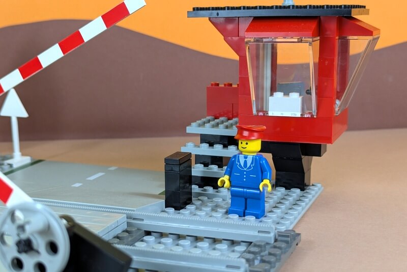 Der Bahnwärter kontrolliert den Lego-Bahnübergang.