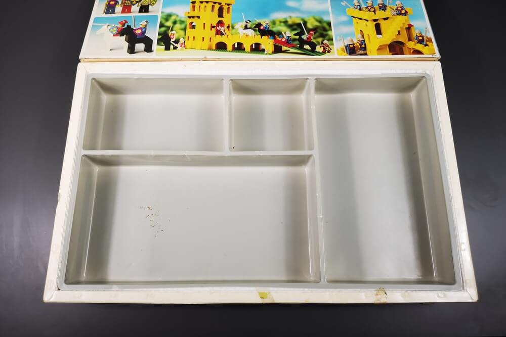 In den 70er-Jahren sahen LEGO-Boxen im Inneren so aus. Eine Kunststoffeinlage war hinter einer Folie, wo die Bausteine sicher aufbewahrt wurden und von außen zu sehen waren.