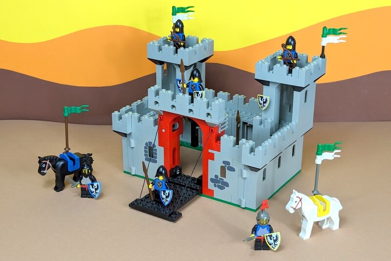 Die Lego-Burg mit der Nummer 6073 vor bunter Kulisse wie in einem klassischen Katalog der 80er-Jahre.