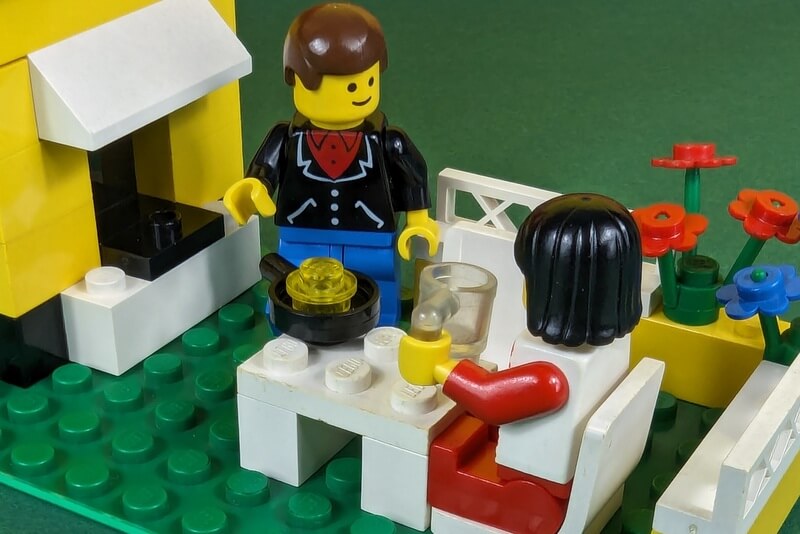 Grillszene aus Lego mit zwei Figuren und einem Spiegelei in der Pfanne.