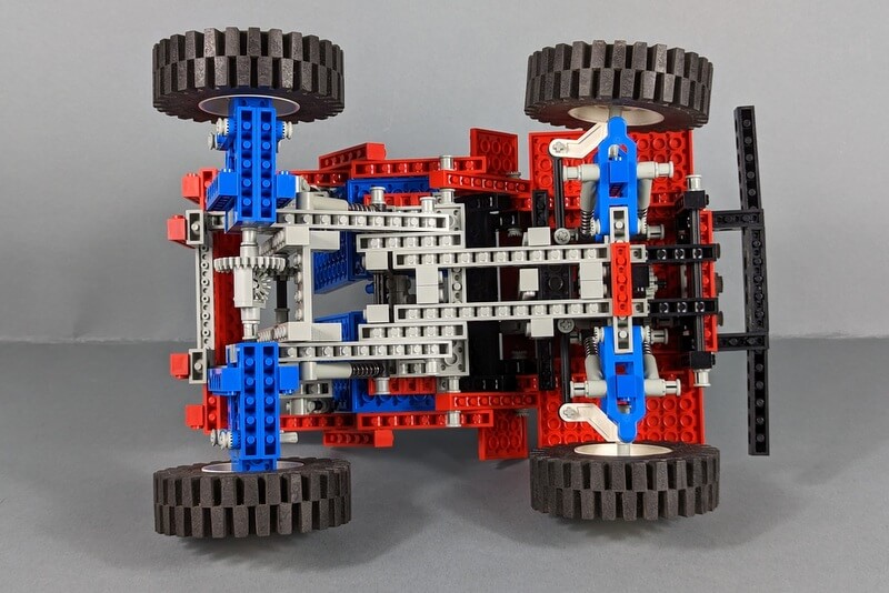 Blick von unten auf die stabil gebaute Bodenkonstruktion des Jeep aus vielen Lego-Bausteinen.