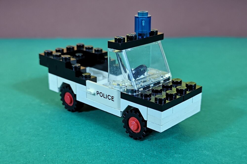 Lego-Polizeiauto in den Farben schwarz und weiß. Typisch für alte Autos aus Lego-Steinen ist die Breite von vier Noppen. Spannender Fakt: Das Polizeiauto ist ein Cabrio und hat kein Dach.
