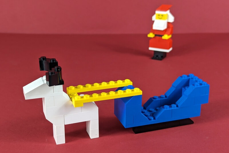 Rentier und Weihnachtsschlitten aus LEGO. Das Rentier sieht aus wie Rudolf, das berühmte Rentier aus dem berühmten Weihnachtslied.