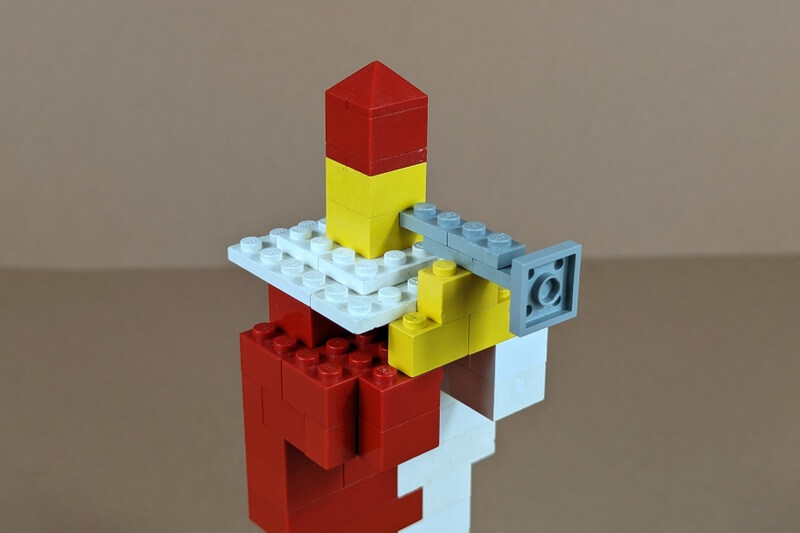 Trompete aus grauen Lego-Steinen gebaut und am Mund einer Lego-Figur.