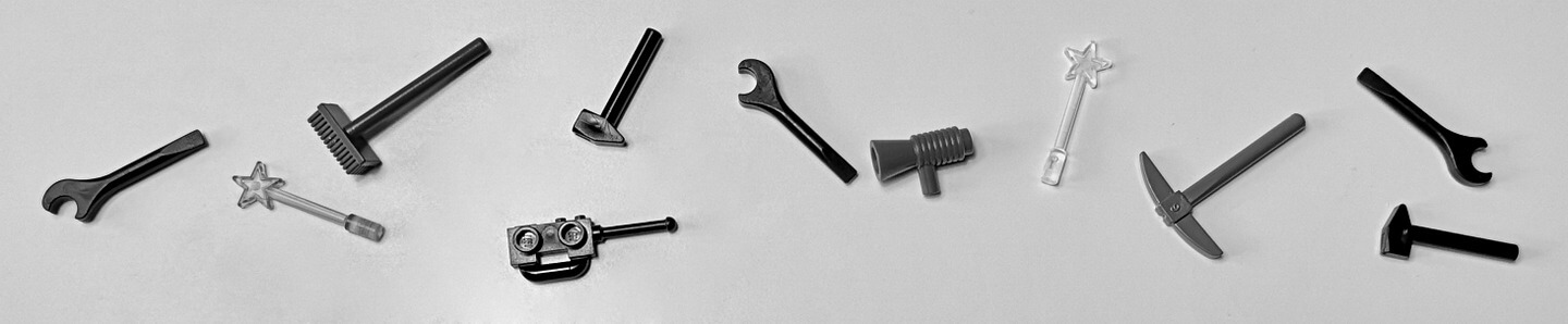 Das Bild zeigt LEGO-Werkzeug. Darunter ein Hammer, ein Besen, eine Hacke und ein Schraubenschlüssel. Zusätzlich sind noch Zauberstäbe, eine Megaphone und ein Walkie-Talkie zu sehen.