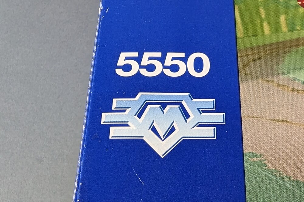Das Modell-Team-Logo in Silber auf blauem Hintergrund. 