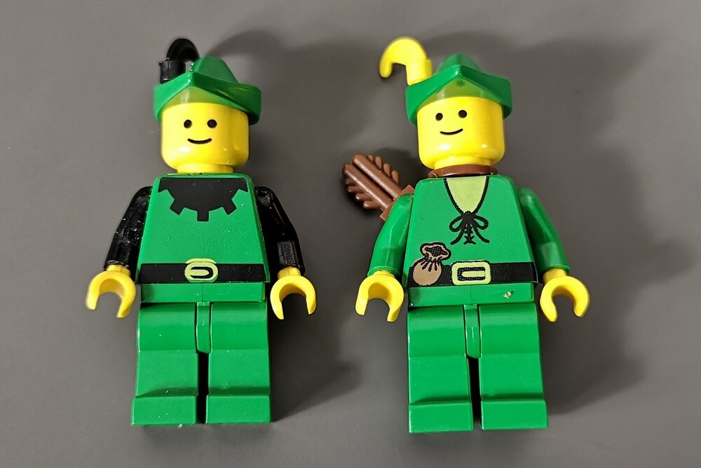 Die Minifigur links hat grüne und schwarze Akzente und die Minifigur rechts ist komplett grün. 